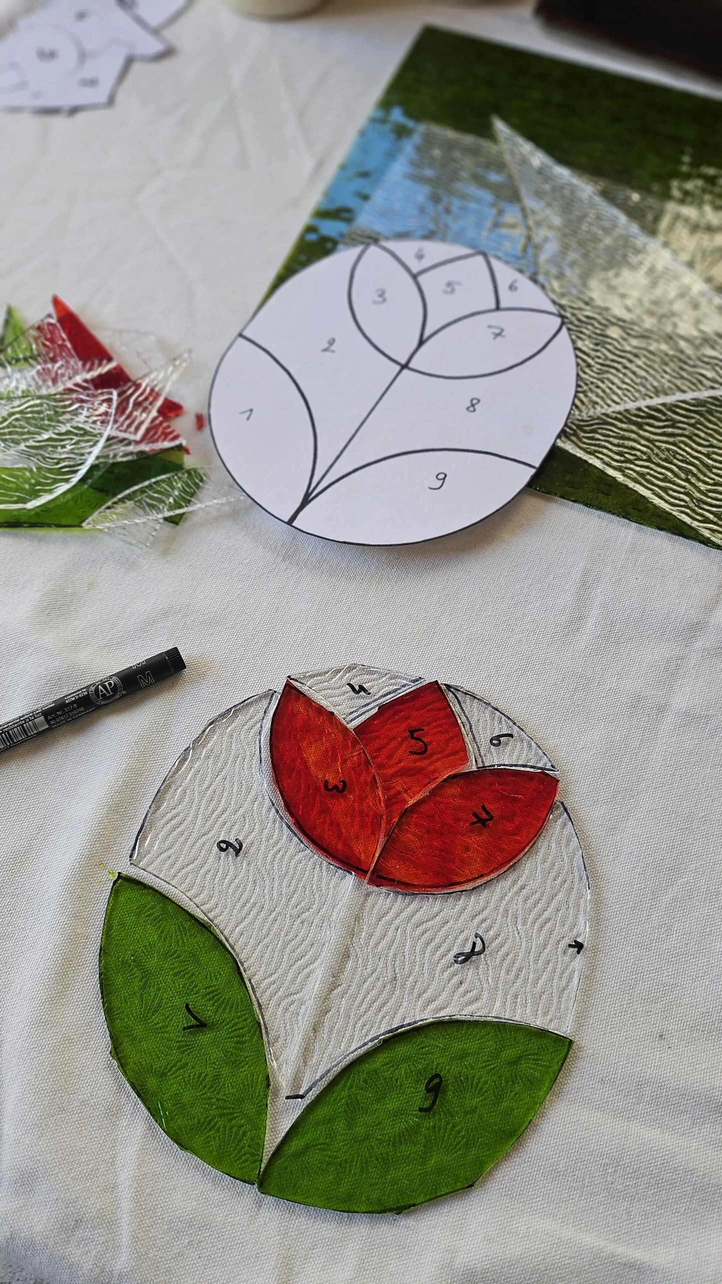 réalisation d'un vitrail représentant une fleur lors d'un atelier d'initiation au vitrail