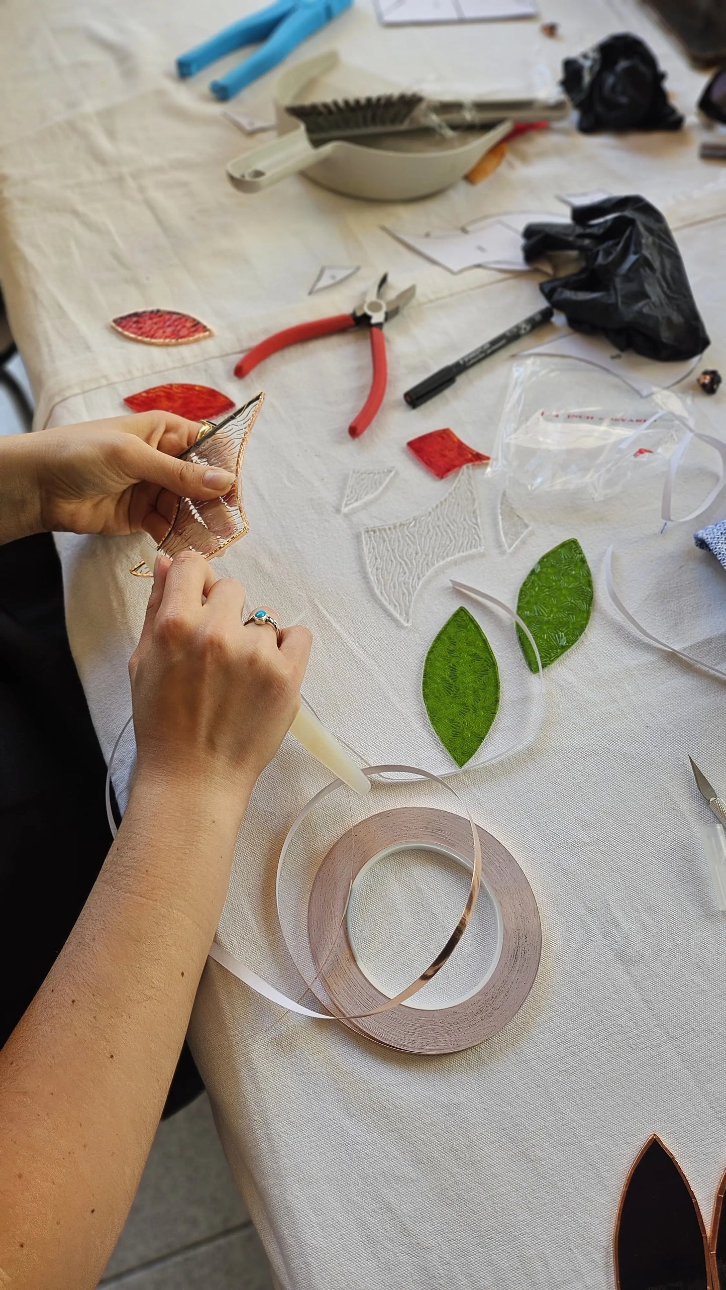 mise en cuivre des pièces de verre poncées au cours d'un atelier d'initiation au vitrail