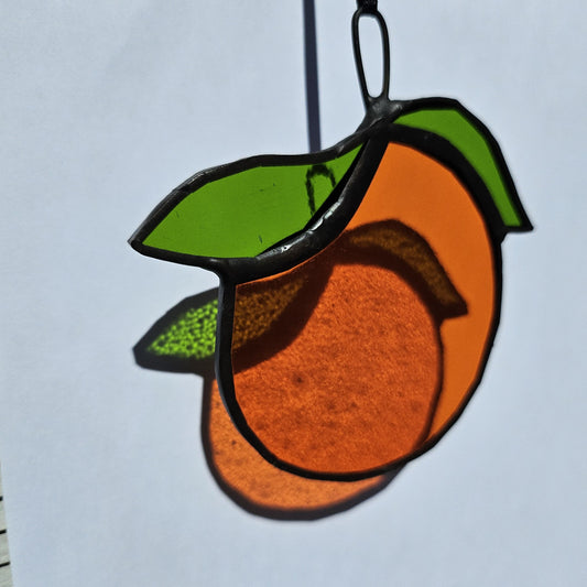 Bright stained glass orange suncatcher. Artisan-crafted décor bringing warmth and light.
Suspension vitrail orange aux teintes lumineuses. Décoration artisanale originale et chaleureuse.