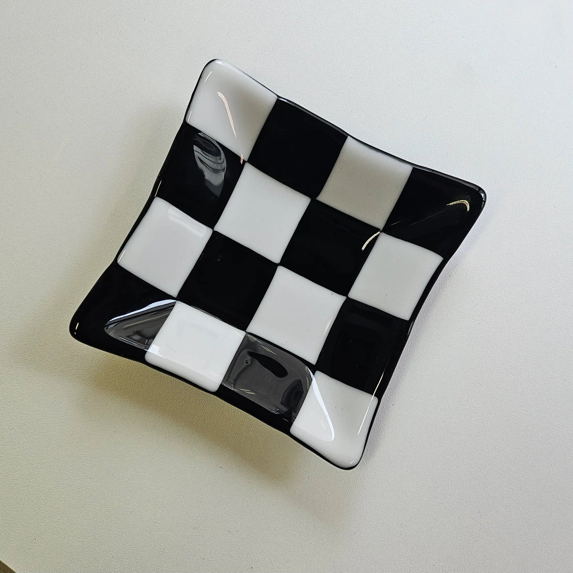 Fused glass tray with black and white decorative design.