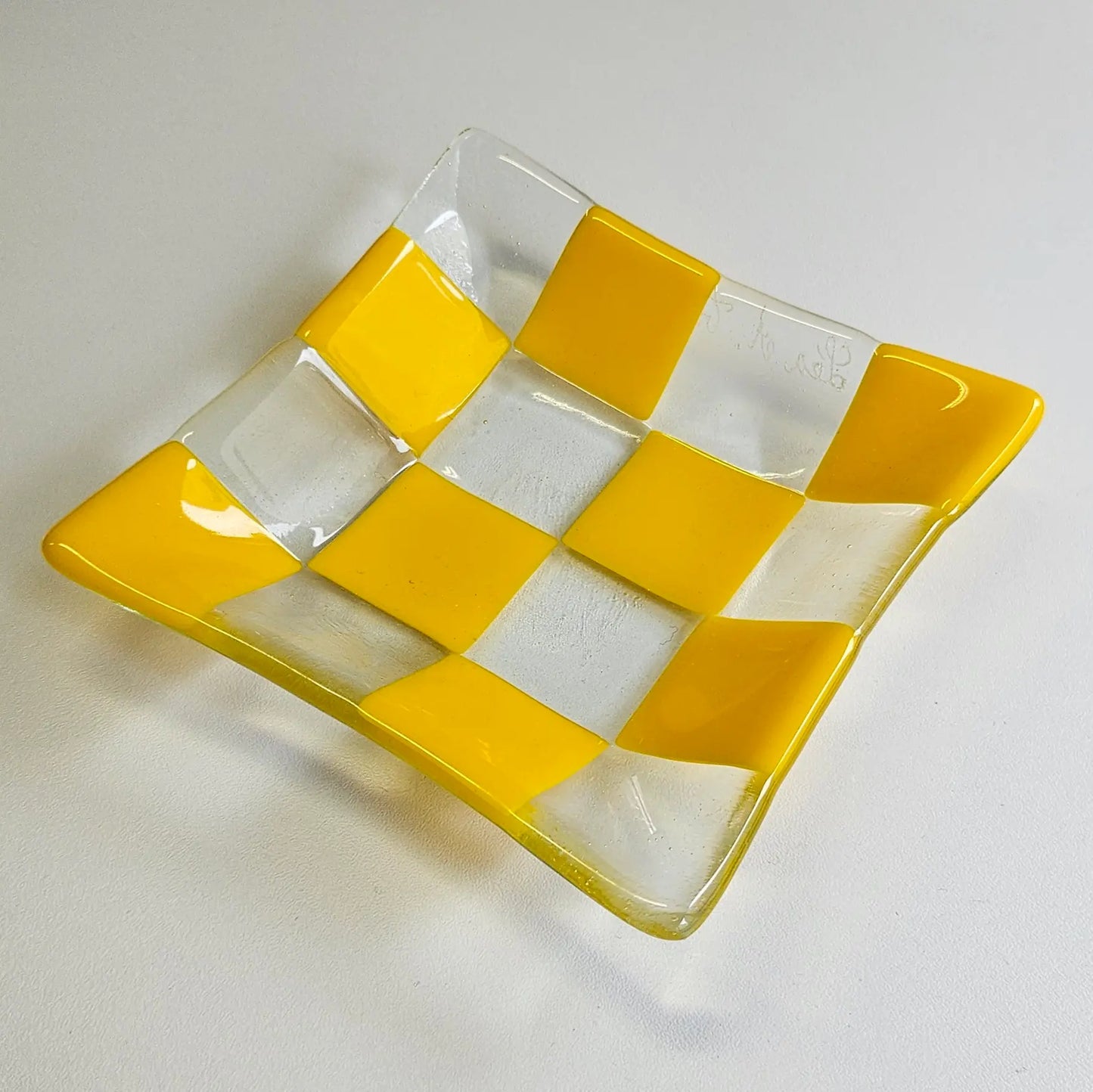 Yellow fused glass tray with transparent checkered design.